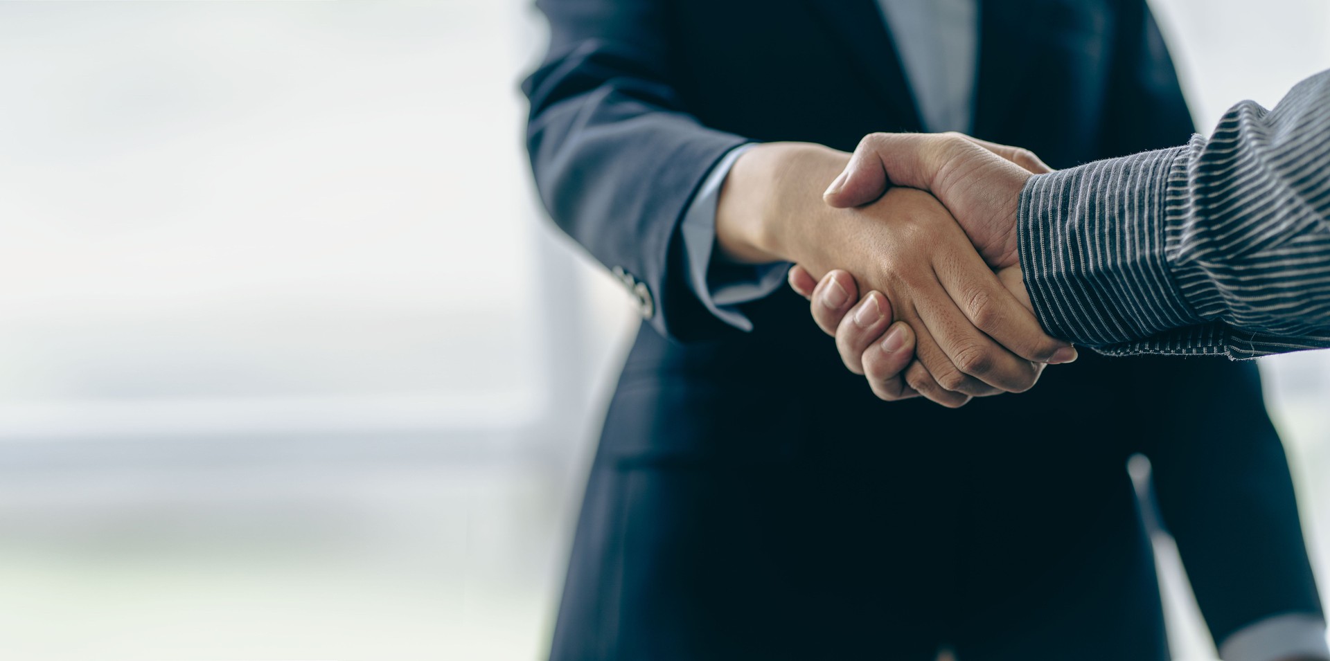 Successful negotiation and handshake concept Two businessmen shake hands with partners to celebrate cooperation and teamwork, mergers and acquisitions. Successful negotiations, business deal concept